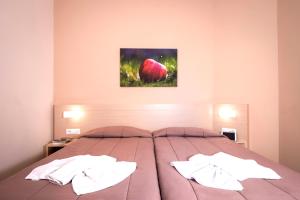 a bedroom with a large bed with two pillows at Atrion Resort Hotel in Agia Marina Nea Kydonias