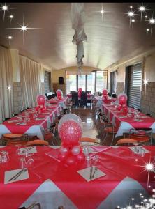 een grote kamer met rode tafels en stoelen met rode tafelkleden bij Stanza vacanza lo stadio in Sibari