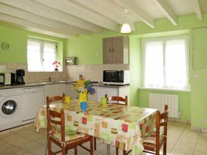 a kitchen with a table with chairs and a table cloth at Holiday Home L'Egven by Interhome in Matignon
