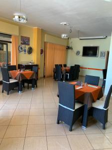 een eetkamer met tafels en stoelen en een tv bij Stanza vacanza lo stadio in Sibari