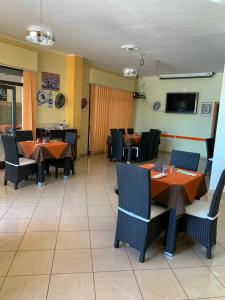 a dining room with tables and chairs and a tv at Stanza vacanza lo stadio in Sibari