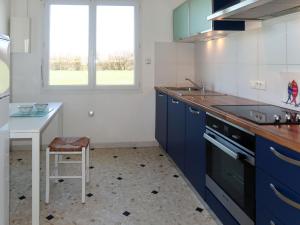 cocina con armarios azules, mesa y ventana en Holiday Home Balades au bord de l'eau by Interhome, en Plozévet 24 fotos más