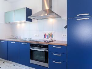 cocina con armarios azules y fogones en Holiday Home Balades au bord de l'eau by Interhome, en Plozévet