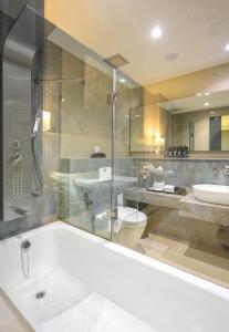a bathroom with a tub and a toilet and a sink at Zenseana Resort & Spa - SHA Plus in Patong Beach