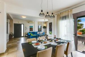 a dining room and living room with a table and chairs at Villa Selena in Stalos