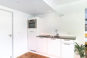 a kitchen with white cabinets and a sink at Villa 1913 in Bergen