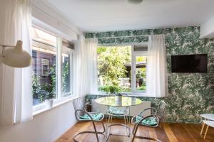 Un comedor con mesa y sillas y ventanas. en Villa 1913, en Bergen