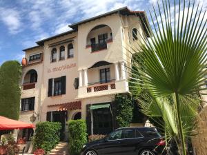 a black car parked in front of a building at La Marjolaine in Juan-les-Pins