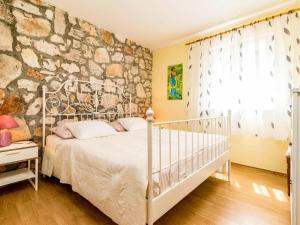 a bedroom with a bed and a stone wall at Holiday Home Glavica by Interhome in Medaki +27 photos