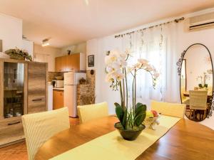 a dining room table with a vase of flowers on it at Holiday Home Glavica by Interhome in Medaki