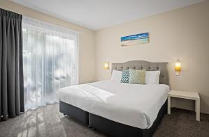 a bedroom with a large bed and a window at Broadwater Resort in Busselton