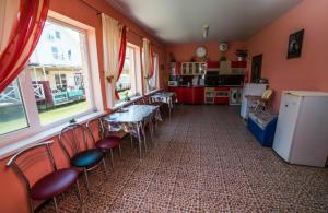 ゴルビツカヤにあるSvetlana Guest Houseのテーブルと椅子、キッチンが備わる客室です。