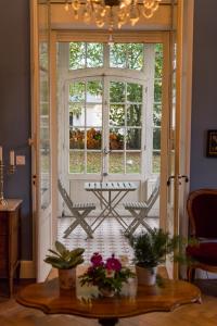 Cette chambre dispose d'une porte ouverte avec une table et des chaises. dans l'établissement Le Clos Des Ormeaux, à Vineuil