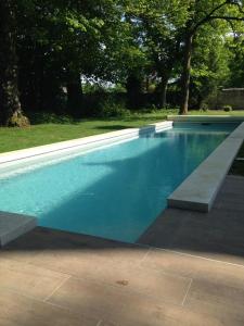 a swimming pool with a bench in a yard at Le Clos Des Ormeaux in Vineuil