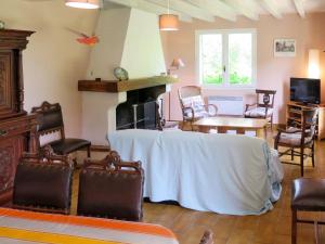 a living room with a table and a fireplace at Holiday Home Cherte by Interhome in Uza