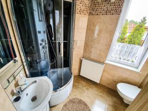 a bathroom with a shower and a sink and a toilet at Villa Róża pokoje & apartamenty in Łeba +161 photos