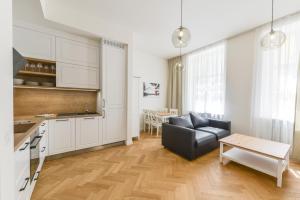 een keuken en een woonkamer met een bank en een tafel bij Brand New Apartment next to Old Town Square in Praag