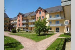 an apartment complex with a dirt road in the yard at Chez Patrick in Grandcamp-Maisy