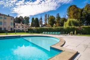 a swimming pool in a yard with chairs and a building at Best Western Plus Hotel Villa Tacchi in Gazzo