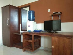 een kamer met een bureau, een tv en een monitor bij Hotel Abad Baru 1 in Pangandaran