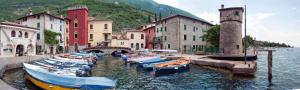 a group of boats are docked in the water near buildings at Casa mobile-Camping Bella Italia in Peschiera del Garda