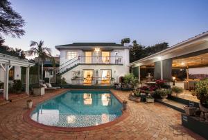 a house with a swimming pool in front of a house at Shandon Lodge Guest House & Spa in Nelspruit