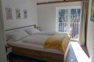 1 dormitorio con 1 cama grande y ventana en Ferienwohnungen Schönbachtal, en Drachselsried