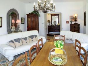 uma sala de estar com uma mesa e sofás brancos em Holiday Home Primavera - GAL200 by Interhome em Galéria