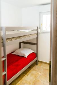 a bedroom with two bunk beds with a red blanket at Apartment A Suara di Mare by Interhome in Ghisonaccia +7 photos
