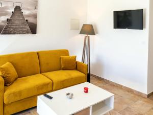 a living room with a yellow couch and a coffee table at Apartment A Suara di Mare by Interhome in Ghisonaccia