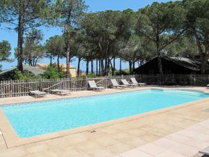a swimming pool with lounge chairs and a fence at Holiday Home Chalet 2 pers by Interhome in Calvi