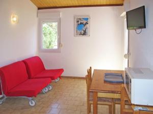sala de estar con sofá rojo y mesa en Apartment Thalassa - CAL200 by Interhome, en Calvi