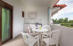 a small white table and chairs on a balcony at Fantasia Studios and Apartments in Neos Marmaras