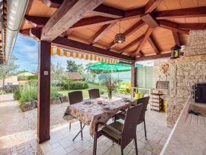 a patio with a table and chairs under a pergola at Apartment Pina - PZN317 by Interhome in Tinjan