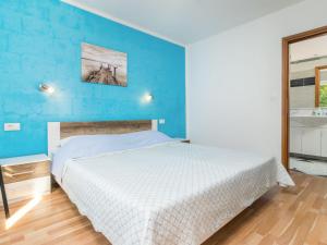 sypialnia z łóżkiem i niebieską ścianą w obiekcie Holiday Home Antoni by Interhome w mieście Pićan