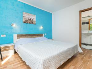 a bedroom with a bed and a blue wall at Holiday Home Antoni - IPC106 by Interhome in Pićan