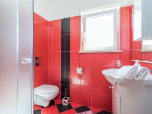 a red bathroom with a toilet and a sink at Holiday Home Antoni - IPC106 by Interhome in Pićan