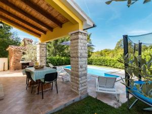 patio ze stołem i krzesłami przy basenie w obiekcie Holiday Home Antoni by Interhome w mieście Pićan