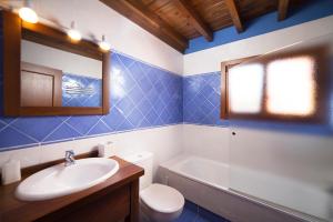 a bathroom with a sink and a toilet and a tub at Apartamentos La Calvera in Parres de Llanes