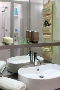 bagno con lavandino bianco e mensola con asciugamani di Casa mobile-Camping Bella Italia a Peschiera del Garda