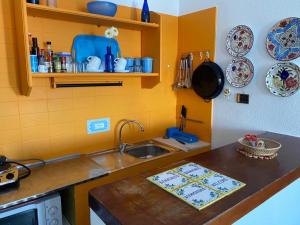 una cucina con lavandino e bancone con piatti di Gecko Blue, Es Pujols ET - 75 PL a Es Pujols Altre 2 foto