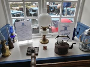 a table with a lamp and a tea pot on it at Bridge House Bed & Breakfast in Boscastle