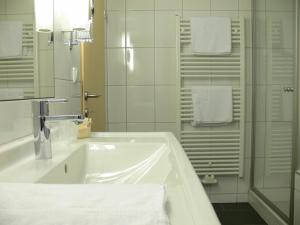 a white bathroom with a sink and a shower at Gasthaus Engel in Bezau