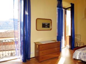 a bedroom with a bed and a dresser and a window at Apartment Roma by Interhome in Porto Valtravaglia +17 photos