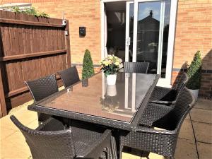 einen schwarzen Tisch mit Stühlen und eine Vase aus Blumen in der Unterkunft Malt House in Newmarket