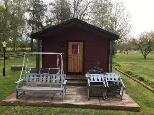 une petite cabine avec deux chaises et une terrasse couverte dans l'établissement Stuga, à Romakloster