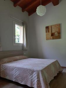 1 dormitorio con 1 cama con colcha blanca y ventana en B&B LE AGAVI, en Borso del Grappa