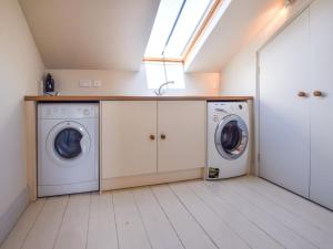 a laundry room with a washer and dryer at Oldbury Barn in Cheltenham