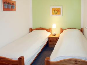 ノルデンにあるApartment Nordblick by Interhomeのベッド2台、デスク、ランプが備わる客室です。
