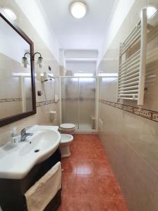 a bathroom with a sink and a toilet and a mirror at Hotel Il Quadrifoglio in Cerignola
